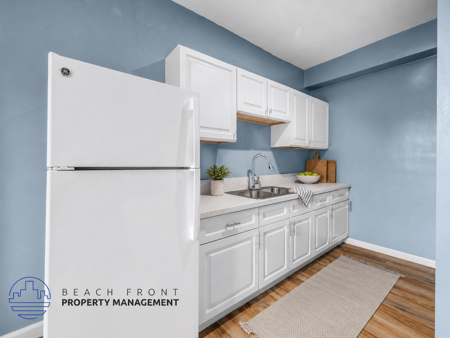 A kitchen with white cabinets and a white refrigerator.